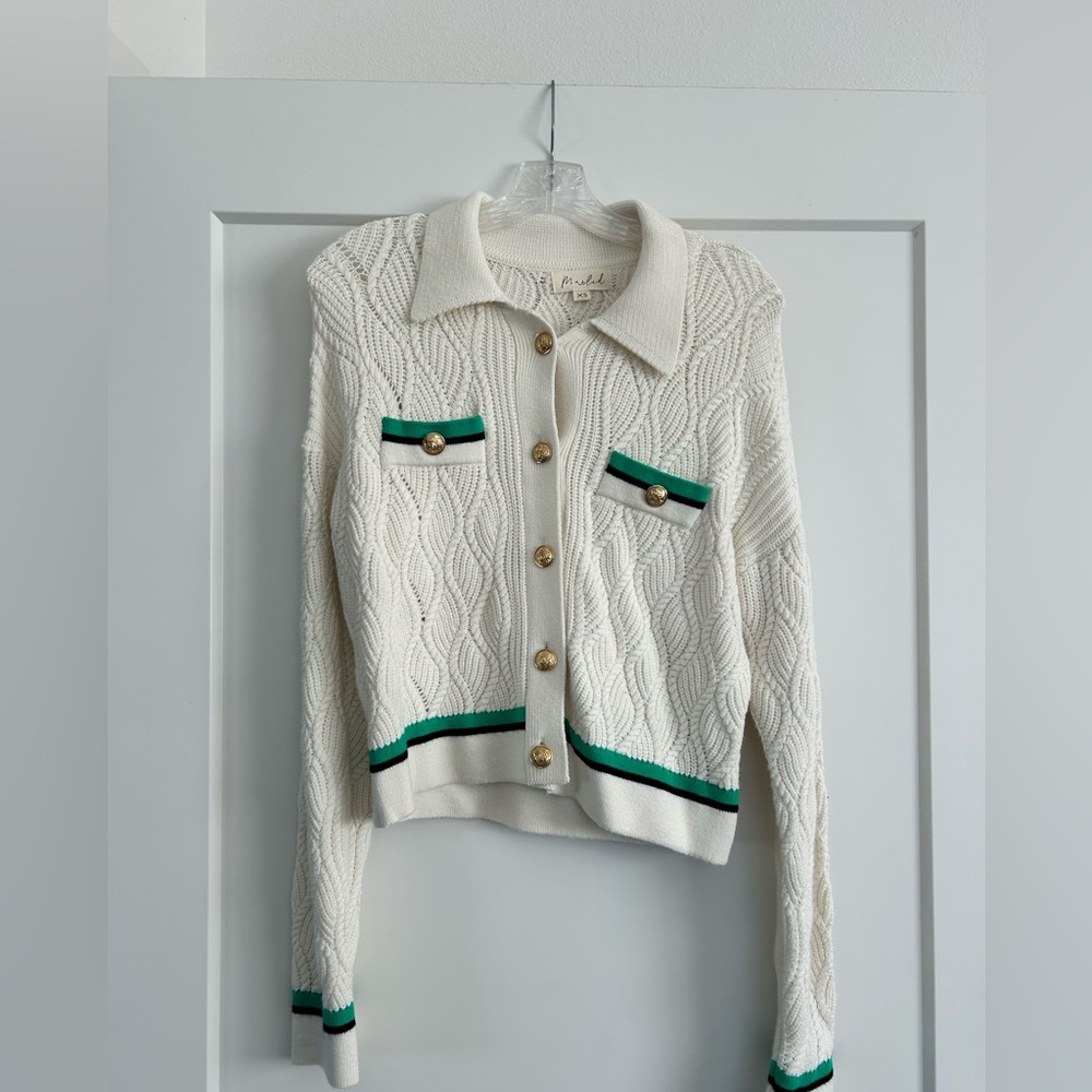 Cream cardigan with green and black detail and gold buttons